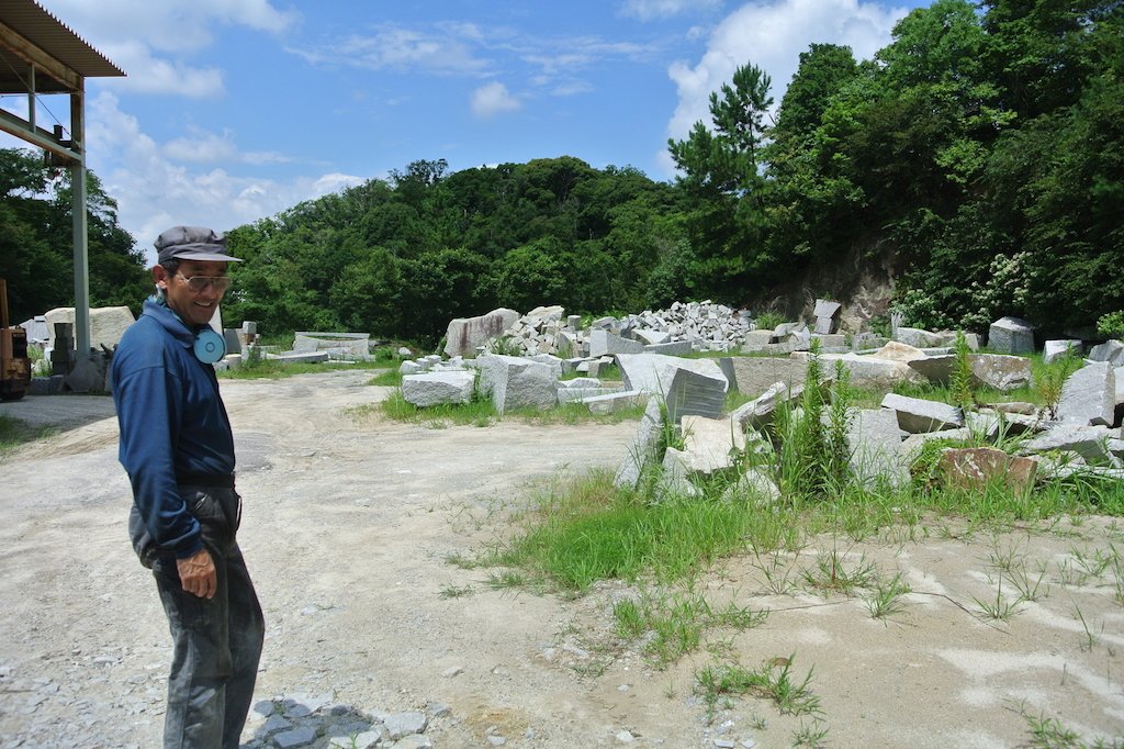 （有）中根石材の中根浩司さん。これらはすべて中根さんが切り出した石。ものすごい数です
