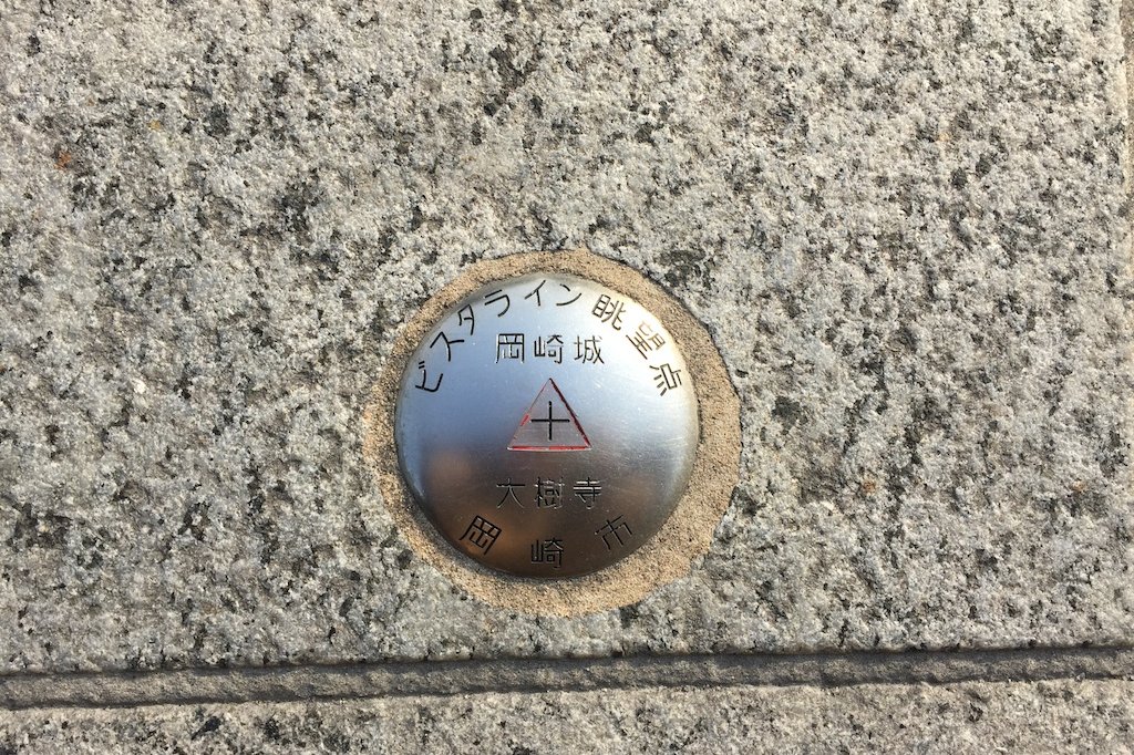 山（三）門の前に埋められている直径5cmの金属鋲。これと同じものが、岡崎城までを結ぶ直線上に全部で92箇所設置されているとか