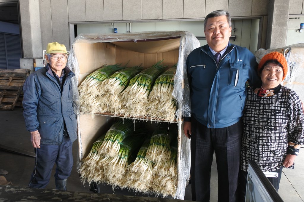 荒木部長（中央）と法性寺ねぎの生産者、近藤さんご夫妻